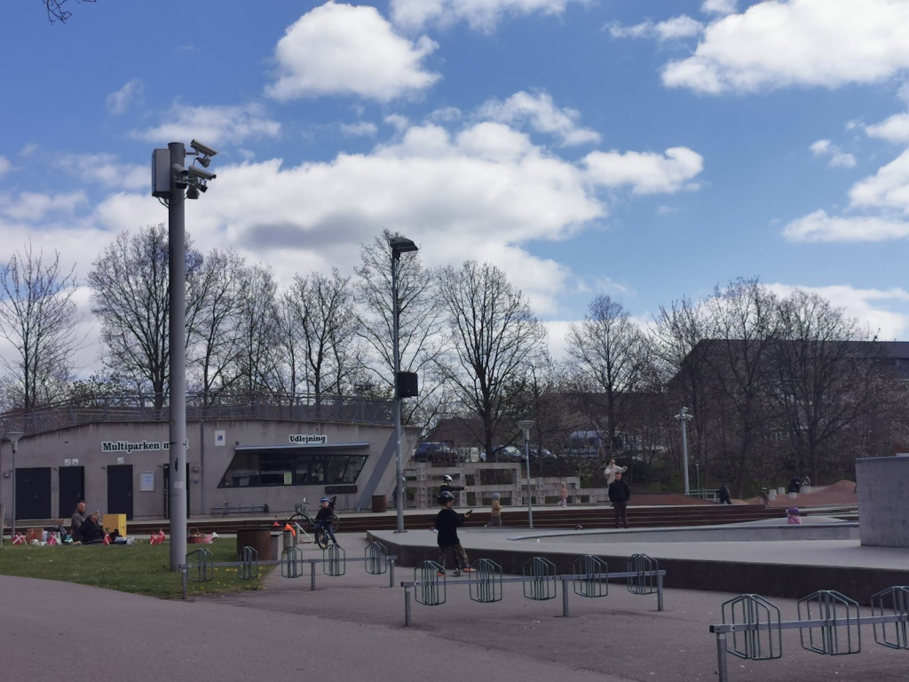Multiparken Helsingør (MPH) is Denmark’s largest skatepark. The park has everything from bowls to ledges and is divided into different levels which promote growth and challenge the skaters. The park is made of concrete and steel in order to ensure the vitality of the park. Furthermore, the park has an office for the volunteers who run the park and a café that sells both foods and drinks. The park also has an outdoor music centre to create the right atmosphere and good lighting at nighttime.The street course of &nbsp;Multiparken is a mixed blessing even though it provides a great example as to how a skatepark can combine architecture and skate obstacles. The park suffers from having a lot of staircases and an uneven foundation. The stairs can seem like heaven or hell depending on the skater’s preferences. The street course can challenge even the most experienced skaters, if he wants to take advantage of it.However, the street course has a fatal error and that is the foundation. The foundation of the park, except for the stairs, is made of large concrete flagstones, which makes the foundation uneven at times and make it not fun to skate on. In some places, the stones are rocking or even broken. However, when looking at the big picture, it is a minor detail.The park offers a lot of ledges, rails and banks. The sky is the limit when it comes to being creative at this park. Because of the size of the park,, it is almost always possible to find lines or a specific spot for a ‘private’ session. In addition, the street course can challenge technically skilled skaters with it’s crooked angles, ledges and at times peculiar construction style.Helsingør Multipark’s concrete bowl is by far the biggest attraction of the park. The park follows a circular patterns and offers challenges to skaters of all levels. The bowl has both a skate pit, an oververt and a drop-in. Furthermore, the bowl is built in a way that makes it possible to divide it into three different levels that can be skated independently so that all skaters will have the greatest possible experience.The first part of the beginner’s level is about 1.5 metres high and ends in a skate pit which makes it easy for skaters to keep to one end of the bowl if they want.The second part is a little deeper, about 2,5 metres. Here, you will also find the over overt. It is possible to make larger airs and higher grinds and to gain more speed.The third and last part of the bowl is a deep, almost segregated bowl which measures up to 4 metres. This is for the very experiences skaters.Generally, the concrete bowl of Helsingør Multipark is worth a visit – even you have to travel far to get there.There are a lot of events at Multiparken. In the summer of 2013, Helsingør hosted the Danish national scooter championship. In addition, the park is home for countless free concerts during the summer.Helsingør Multipark was built as a part of an integration debate in the local community. Helsingør is well-known for its diversity and the park is an attempt to build a bridge between ethnic groups and furthermore to reduce the local crime rate by building interests in the sports instead. Overall, the goal of the park is to help create more tolerance and understanding when it comes to different cultures in the community.Helsingør has found it important to support its youth and their interests as street culture gains a footing in Danish culture, especially in the youth culture. The park’s purpose is to embrace all aspects of street culture, including skating, parkour, graffiti and musicMore information about the project and its collaborators can be found on their website: http://www.mp-h.dk/