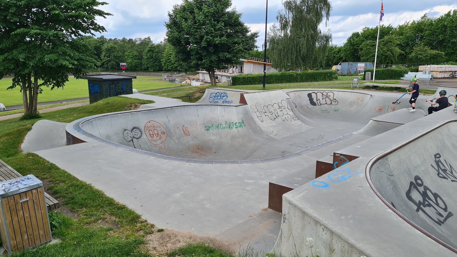 Hørsholm skatepark is a newly built made of black wood and steel on a concrete foundation. The park’s quarter pipes and banks are placed at the edge of the park so that skaters can maintain speed and flow throughout the park. In addition, the obstacles of the park are made of wood so that it is possible to move them around if needed. There is also a large manual pad course with more quarters and grind boxes.The park is definitely worth a visit as the quality of the park and its design is very professional. The transfer course is probably the most unique element of the park. Here, there are both quarter pipes, banks, spines and ledges. This course is perfect for doing airs, transfers and grinds. The park’s mini vert is on the other side. Here, there are great opportunities for you to practise your tricks and the mini vert appeals to all skaters regardless of their level as it is 1,5 metres high.Hørsholm Skatepark has been expanded with a bowl. You can see the bowl in some of our pictures. The bowl is located at Stadionallé 7. The bowl is designed by FRS Beton together with Beaver Concrete. Wonder Concrete and Enr have established the low part of it as well as the mini ramp.Pivotech enriched us with a lot of skateparks: Kolding Skatepark, Feldballe Skatepark and MPH to mention some of them.You can follow Pivotech and their projects on facebook.This expansion was described in August, 2014.