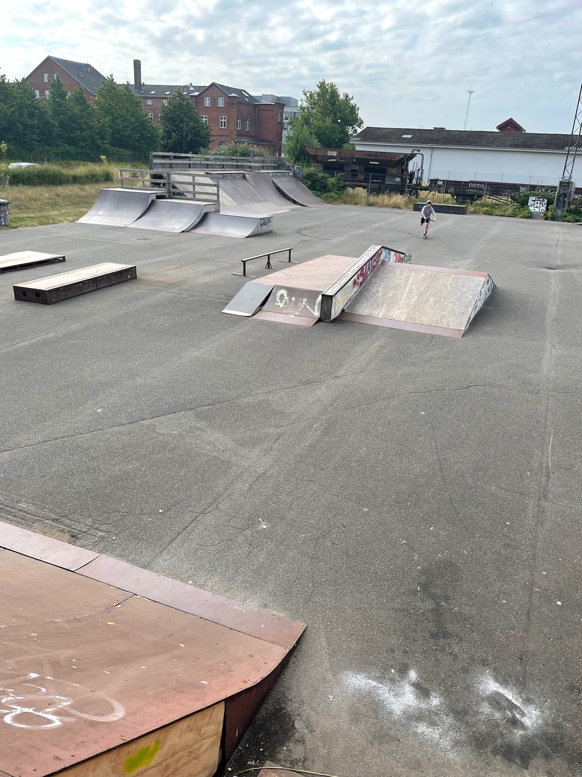 Ungdomenshuset (The youth house) aka. Fredericia Skatepark is made of concrete and wood. It has several banks and quarter pipes made of wood while the more fixed elements like grind boxes and the like are made of concrete. The park is not maintained very well, but all obstacles function as intended. Fredericia skatepark is harmonious. This provides the skaters with a good flow throughout the park. There are also movable flat rails and the like that can be moved as needed. The park is worth a visit if you are in the neighbourhood. However, the park is not necessarily innovative enough to make it worth a visit if you have to travel for to get there. 