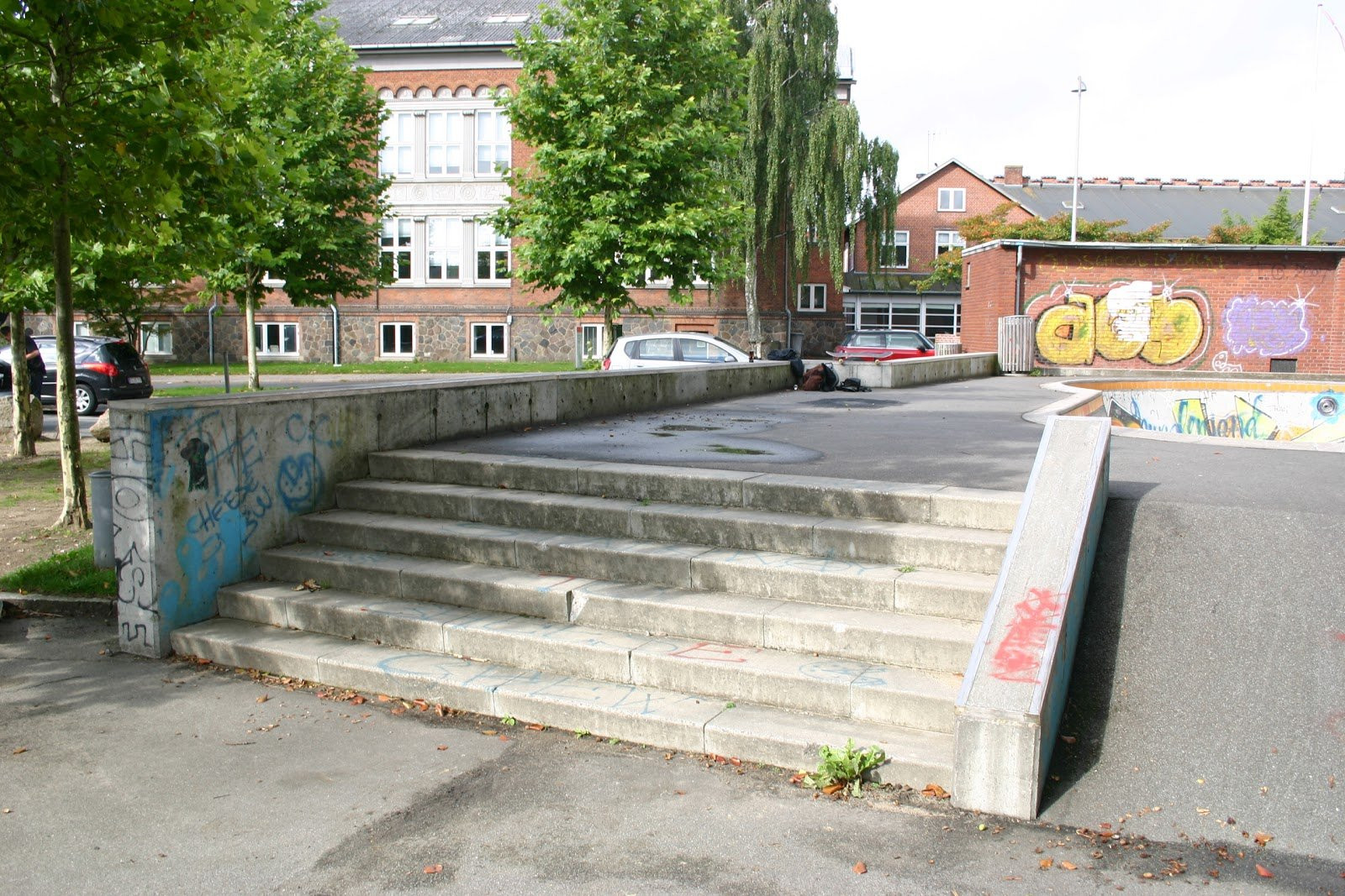 At first glance, Horsens skatepark does not look to be very well maintained. However, as the park is built of concrete on asphalt, all elements function as they should. When the seasons change there are leaves on both the street course and the bowl, however as an experienced skater, you are probably used to that.The street course at Horsens Skatepark could use a little love. The course is centered around down-ledges and a fun box at the end. There are also movable rails at the park and a single stair set. At the corner of the park, the asphalt has been raised and can be used as a bank.As mentioned earlier, the bowl is made of concrete and it has been design like a classic californian swimming pool. There are no steel copings in the bowl, however, there are concrete ledges along the rim. The bowl has two levels. The park is definitely worth a visit if you are from the area. If you are a beginner, the is also good for you. 