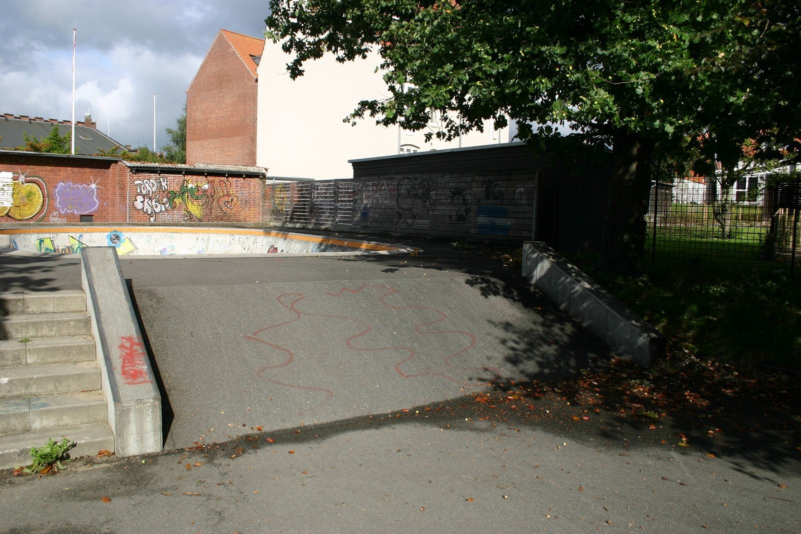 At first glance, Horsens skatepark does not look to be very well maintained. However, as the park is built of concrete on asphalt, all elements function as they should. When the seasons change there are leaves on both the street course and the bowl, however as an experienced skater, you are probably used to that.The street course at Horsens Skatepark could use a little love. The course is centered around down-ledges and a fun box at the end. There are also movable rails at the park and a single stair set. At the corner of the park, the asphalt has been raised and can be used as a bank.As mentioned earlier, the bowl is made of concrete and it has been design like a classic californian swimming pool. There are no steel copings in the bowl, however, there are concrete ledges along the rim. The bowl has two levels. The park is definitely worth a visit if you are from the area. If you are a beginner, the is also good for you. 