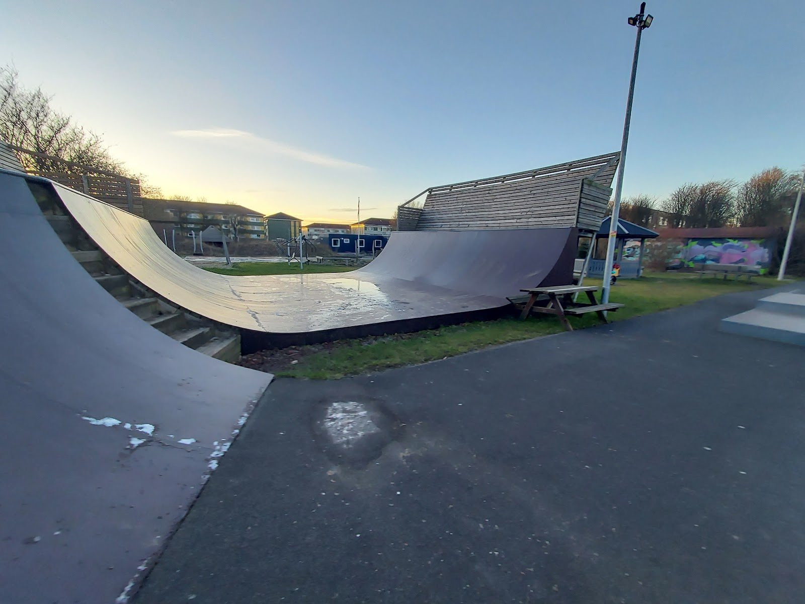 Randers skatepark has been designed according to the traditional rules when it comes to designing a skatepark. Place a quarter pipe in one end and a bank at the other end. Place obstacles in between the two, for example a pyramid box and some grind boxes and you have yourself a skatepark. Even though the park is build according to tradition, it still provides a good, solid and familiar experience for the skaters. The park has recently been renovated with new plates everywhere. The the left of the jump box is a spine. To the right you will find the fly-out box that you can see on the pictures. To the right of it you will see a good, solid fun box and to the right of that there is another fun box with an appurtenant euro gap.The park is definitely worth a visit – even if you have to travel far to get there and regardless of whether you are a beginner or a more experienced skater.&nbsp;At Randers skatepark there is also an old favourite among skaters; the mini vert. The mini vert is new and made of wood. The mini vert has a standard height of about 1.5 metres. &nbsp;