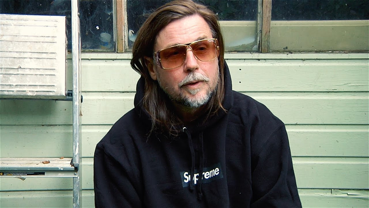 Mark Leckey/Supreme<br /><br />Turner Prize-winning British artist Mark Leckey was born in 1964 and grew up on the outskirts of Liverpool in a working-class family. At 15, Leckey left school, but later attended art college in Newcastle before moving to London in 1997. As a teenager, he came to identify with the Casuals – local factions of young soccer fanatics who sought out designer leisure and sportswear. “It was a kind of dressing up, a disguise,” Leckey has said of the Casuals, “a means of using style to transform yourself.”<br /><br />Leckey’s early understanding of the power of image and shared experience deeply informs his artistic practice. Incorporating video, sculpture, sound, installation and performance, Leckey explores British culture through a distinctly emotional framework. His artworks have examined the relationships between youth, class, public space, popular media and technology, while considering the impacts of nostalgia and memory, both personal and collective. <br /><br />In 1999, Leckey debuted his seminal video essay, Fiorucci Made Me Hardcore – a compilation of found footage chronicling British dance movements from the 1970s to 1990s. The film collages clips from discos, raves, and the emergent Northern soul scene, yet is united by an abstract, almost melancholic soundtrack. The work’s title, Leckey has said, posits that "something as trite and throwaway and exploitative as a jeans manufacturer can be taken by a group of people and made into something totemic, and powerful, and life-affirming."