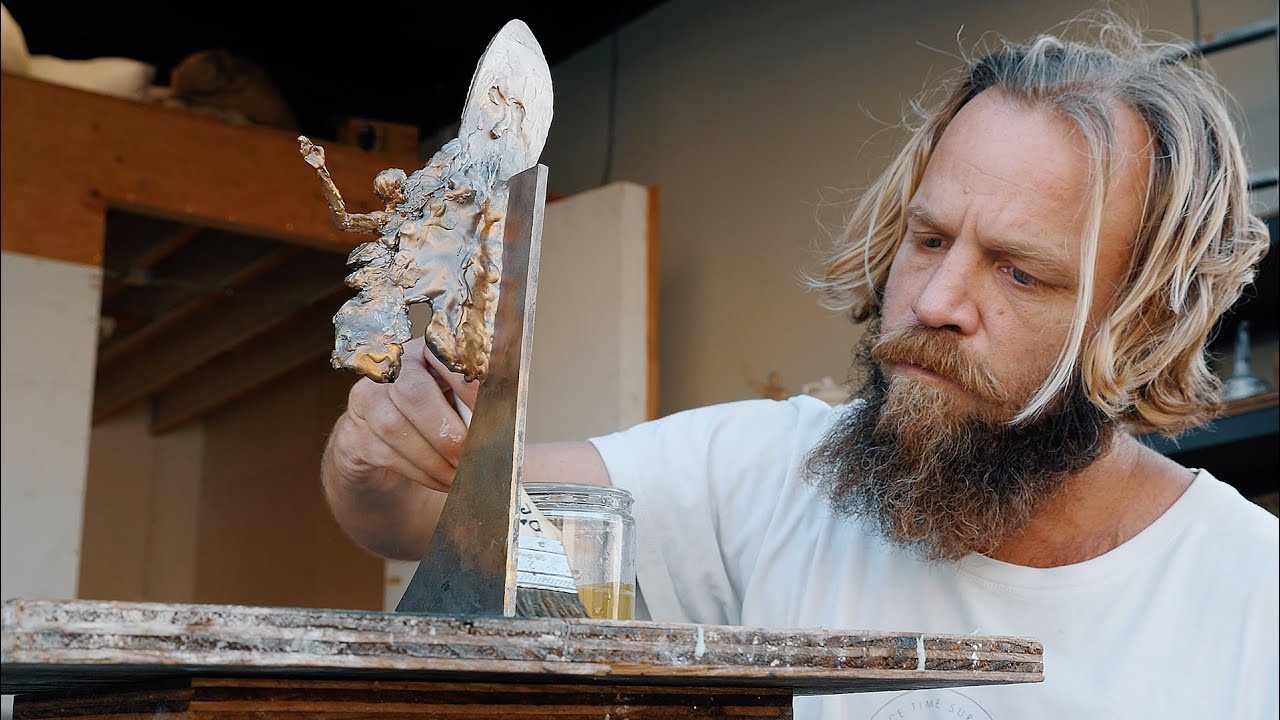 When fine artist Alrik Yuill was only 5 years old, he would collect discarded surf wax he'd find in the sand at his local beach, warmed malleable by the relentless heat of Southern California. With his sand-caked medium, he would sculpt little figurines. This, you could say, was one of his first forays into the art world. Now, a few decades and a very thick beard later, Yuill now works a full-time artist out of his studio in Costa Mesa creating many things--among them beautifully forged abstract bronze sculptures which begin as, funny enough, melted wax.<br /><br />Yuill spends much of his time sculpting abstract pieces based on the human form. He also, thanks to an obsession with the ocean, creates a few surf-themed sculptures, capturing the complex movement required to ride a wave well. Last year, with the support from our friends at Vans, we commissioned Yuill with the task of creating the trophies for the 2018 SURFER Awards. Each award featured a bronze surfer figurine looking like the Ancient Greek “Spear-Bearer” sculpture, which, in Yuill’s mind, pointed to the challenge that the best surfers in the world greet when they enter the water to achieve truly great things.<br /><br />The trophies were so well received that we asked Yuill to design and sculpt something new for this year's SURFER Awards. And sculpt he did. In the edit above, Yuill breaks down his process for making each trophy--an ancient method that that has been used for thousands of years.<br /><br />The trophies, which were carefully transported from Yuill's studio to the North Shore of Oahu this week, are currently at Turtle Bay Resort, waiting to be given to their rightful owners tonight during the 2019 SURFER Awards. Be sure to tune in tonight at 8 PM HST to find out who gets to take home these gorgeous works of art.