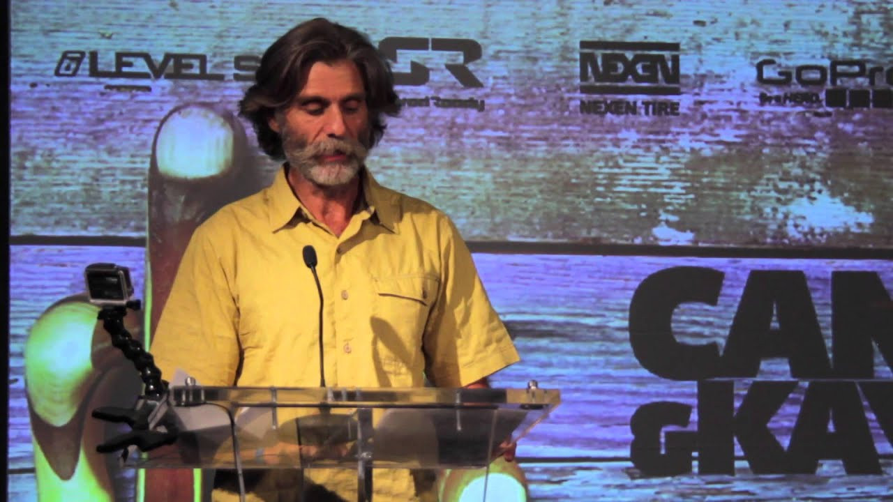 Lecky Haller accepts the 2014 Lifetime Achievement Award on behalf of honoree Jamie McEwan. 2013 Lifetime Achievement honoree Rob Lesser presents the award to the late McEwan, a decorated, respected, and influential paddler who affected the life of Haller, his 1992 Olympic C-2 race partner, as well as countless other slalom, expedition and everyday recreational paddlers.