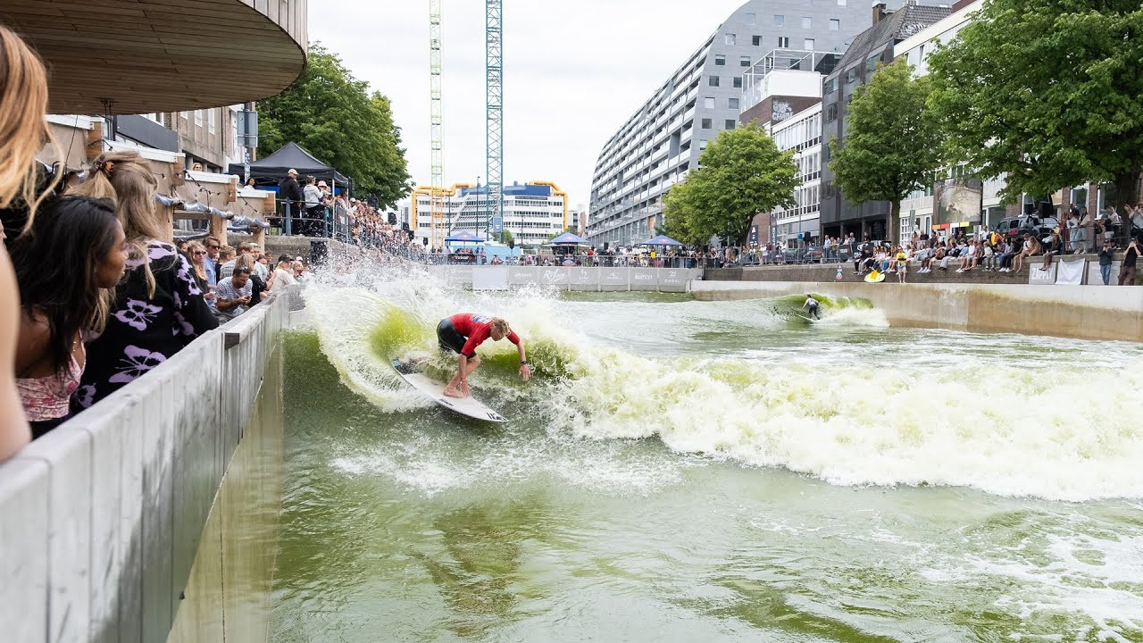 The RiF010 wave pool, right in the heart of Rotterdam, Netherlands, hosted the spectacular first edition of Red Bull Pool Clash.<br /><br />Under loud cheers from a crowd on the quay, 39 surfers competed in a unique format that focused on creativity, flow, and risk.<br /><br />Among the men, Oliver Heintz won the title of King of the Pool. In the finals, he impressed the judges with his sharp turns and consistent surfing style.<br /><br />In the women's division, Jessy van Wijk pulled out all the strings and showed what control means in a wave pool, winning the title Queen of the Pool.<br /><br />Surf Show in Town<br /><br />The setting of the event was anything but traditional.<br /><br />No ocean or unpredictable conditions, but identical, controlled waves in a wave pool in the middle of the city.<br /><br />According to Stef van Noordennen, Dutch champion in 2024, the wave pool creates a unique arena setting: "There were so many people along the side, which is mega intimidating, but also very cool."<br /><br />Participants of All Levels<br /><br />In addition to established names from the surfing world, such as Julia Heijmans and Ruben Zonneveld, ambitious surfers who dared the challenge also participated.<br /><br />A total of 39 participants, 31 men and 8 women (from pros to local talents), took on the challenge.<br /><br />The tournament began with a joint jam session, after which surfers could qualify for the 1-on-1 battles.<br /><br />A three-person jury consisting of Eveline Hooft, Hans van den Broek, and Yannick de Jager chose the winner by voting blue or red.<br /><br />A new dimension to surfing<br /><br />Red Bull Pool Clash showed how wave pools can add a new dimension to surfing.<br /><br />Thanks to the identical waves in the wave pool, all surfers were given equal opportunities.<br /><br />"While judging, I pay particular attention to the power the surfers give and the maneuvers they make. The consistent wave challenged the surfers to take as much risk as possible," said judge Eveline Hooft.<br /><br />Footage: Red Bull